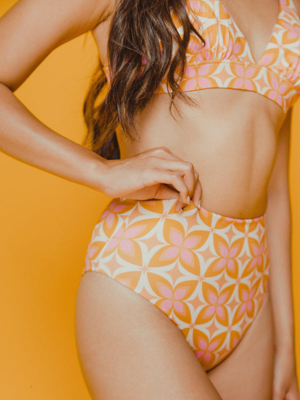 Bikini swim bottoms with high cut leg opening, low booty coverage and high waist with bright pink and orange geometric 70s print